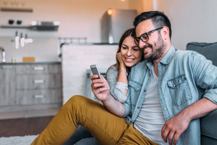 A couple watches Instant Experience ads on their phone.