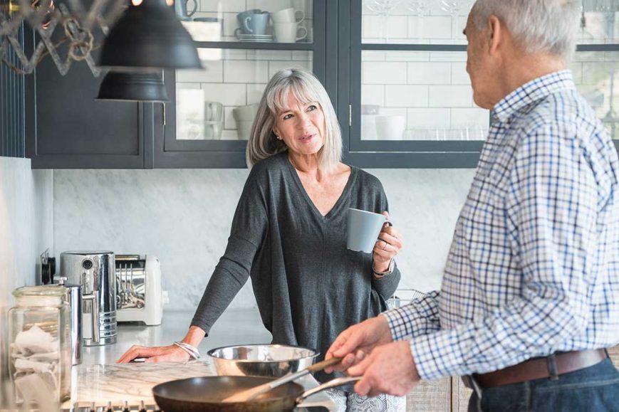 Adult couple cooks in their spacious kitchen.