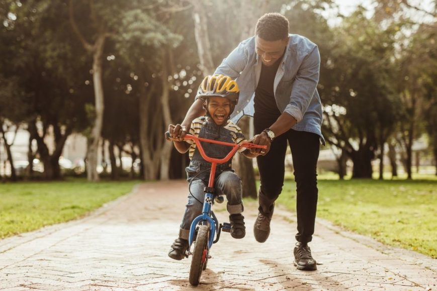 Father helping son ride bike