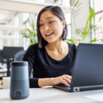 Businesswoman talking to virtual assistant at her desk.